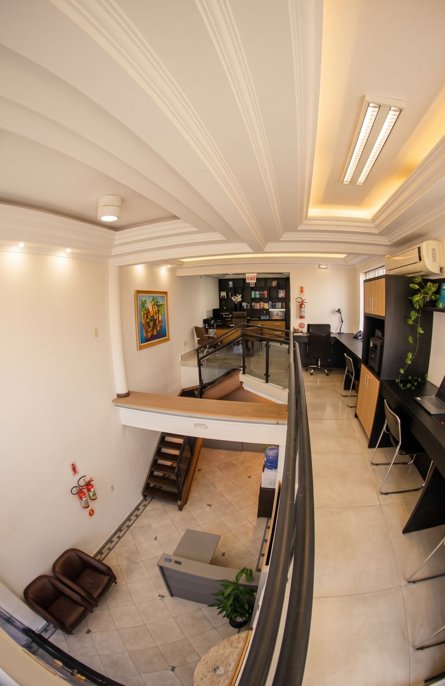 Vista do mezanino com as estações de trabalho e a recepção no andar de baixo